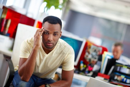 Photo for Is it Friday yet. a handsome young man suffering from a headache at work - Royalty Free Image