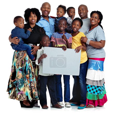 Photo for The biggest families are the best. Studio shot of a large african family holding a blank board, isolated on white - Royalty Free Image