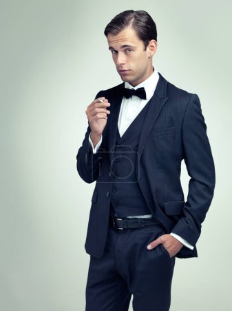 Photo for If confidence was currency, hed be even wealthier. A studio portrait of a dapper young man smoking - Royalty Free Image