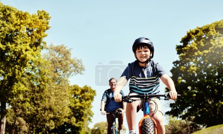 Foto de Pedaleando por el parque. un niño y su padre montando juntos en sus bicicletas - Imagen libre de derechos