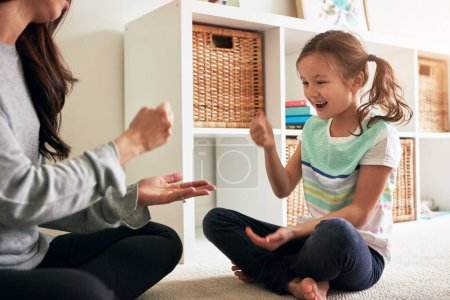 Photo for Rock, paper, scissors. a little girl playing rock, paper, scissors with her mother at home - Royalty Free Image