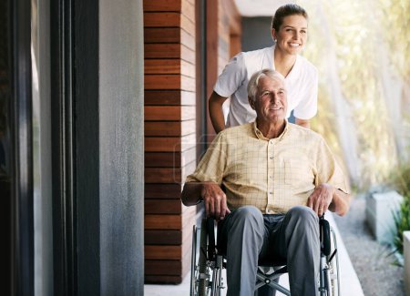 Téléchargez les photos : L'air frais est bénéfique pour la récupération. une infirmière s'occupant d'un patient âgé en fauteuil roulant à l'extérieur d'une maison de retraite - en image libre de droit