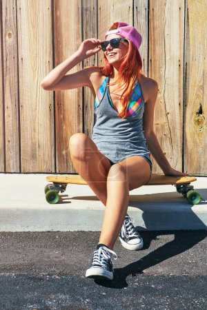 Photo for Dont be shady now. a young woman hanging out on the boardwalk with her skateboard - Royalty Free Image
