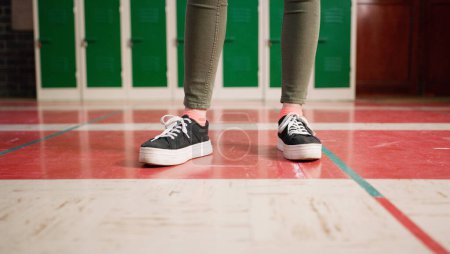 Photo for Someone got new shoes. Low angle shot of an unrecognizable students shoes with the student standing and waiting to go to class inside of a school - Royalty Free Image