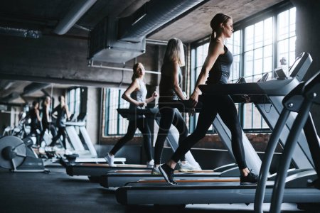 One step at a time. Full length shot of three attractive and athletic women working out in the gym
