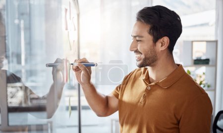 Photo for Happy man writing on glass for ideas, planning and project management goals or business schedule in office startup. Young, creative Asian person brainstorming on window for solution or development. - Royalty Free Image