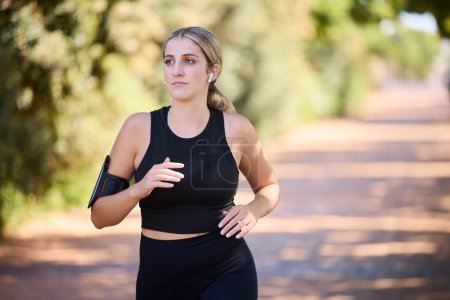 Photo for Music, runner or woman running in park training, cardio exercise or endurance workout for marathon. Sports, fitness or healthy girl athlete exercising on jog streaming audio or radio song in nature. - Royalty Free Image