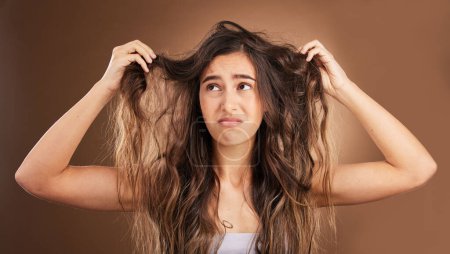 Problem, hair loss and sad woman in studio for beauty, messy and damage against brown background. Haircare, fail and unhappy girl frustrated with weak, split ends or alopecia while posing isolated.