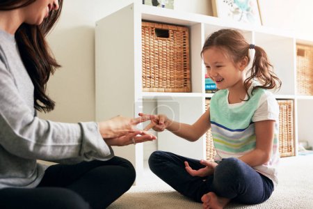 Photo for We both threw scissors. a little girl playing rock, paper, scissors with her mother at home - Royalty Free Image