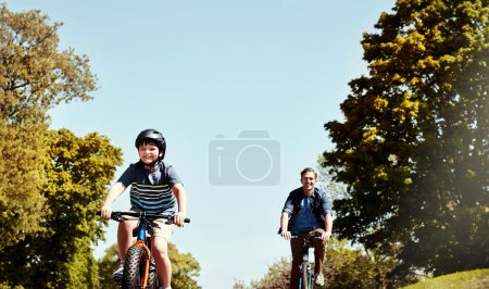 Foto de Corre hasta el final, papá. un niño y su padre montando juntos en sus bicicletas - Imagen libre de derechos