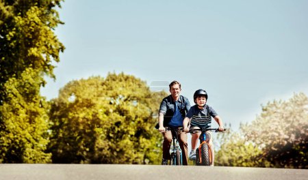 Foto de De un lado a otro en sus bicicletas. un niño y su padre montando juntos en sus bicicletas - Imagen libre de derechos