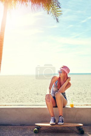 Photo for Skate to wherever your heart takes you. a young woman hanging out on the boardwalk with her skateboard - Royalty Free Image