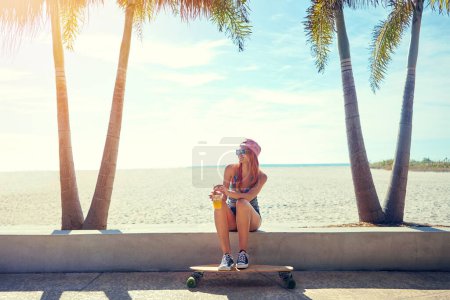 Photo for Im a better person when Im out skating. a young woman hanging out on the boardwalk with her skateboard - Royalty Free Image