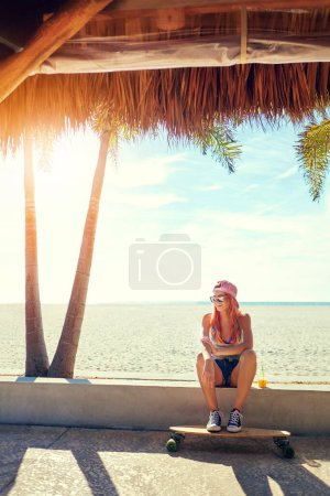 Photo for Good times and longboard rides. a young woman hanging out on the boardwalk with her skateboard - Royalty Free Image