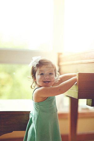 Llegas justo a tiempo para mi actuación en solitario. Retrato de una adorable niña tocando en un piano el hogar