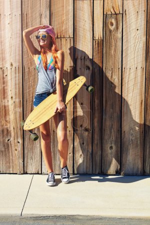 Photo for Skating can fix anything. a young woman hanging out on the boardwalk with her skateboard - Royalty Free Image