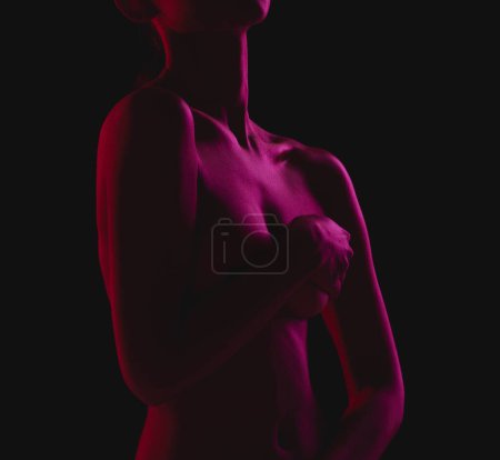 Foto de Mujer desnuda, sexy y desnuda cuerpo cubriendo tetas sintiéndose sensual aislado en un fondo de estudio oscuro para el deseo sexual. Seducción, arte y piel por modelo erótico femenino con las manos en los pechos o el pecho. - Imagen libre de derechos
