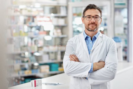 Photo for Dont hesitate to stop by without buying anything. Portrait of a pharmacist standing with his arms crossed in a drugstore. All products have been altered to be void of copyright infringements - Royalty Free Image