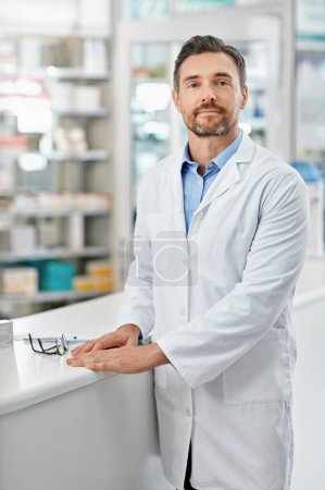 Téléchargez les photos : Apportez vos médicaments sans aller chez le médecin. Portrait d'un pharmacien debout dans une pharmacie. Tous les produits ont été modifiés pour être exempts de violation du droit d'auteur - en image libre de droit