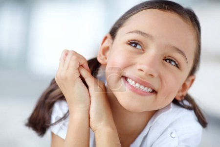 Photo for The age of innocence. A cute girl with pigtails smiling and looking up - Royalty Free Image