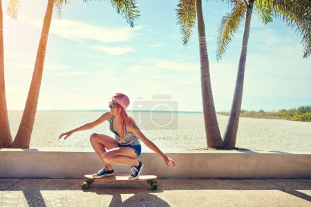 Photo for Shes pretty skilled. a young woman hanging out on the boardwalk with her skateboard - Royalty Free Image