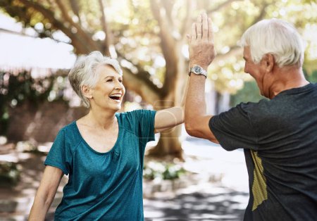 Photo for Keeping each other motivated. a senior couple high fiving each other while out for a run together - Royalty Free Image
