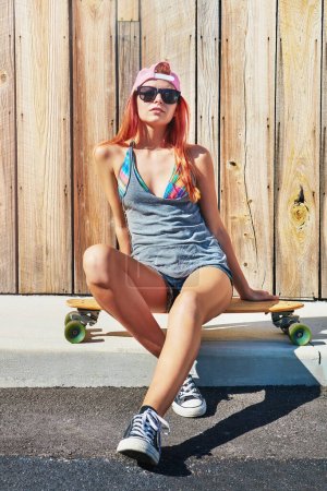 Photo for I can be myself when Im out skating. a young woman hanging out on the boardwalk with her skateboard - Royalty Free Image