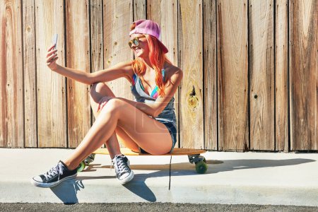 Photo for This selfie will get so many likes. a young woman taking a selfie while sitting on her skateboard - Royalty Free Image