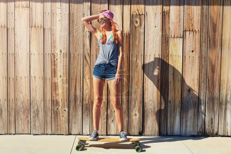 Photo for I do it for the love. a young woman hanging out on the boardwalk with her skateboard - Royalty Free Image