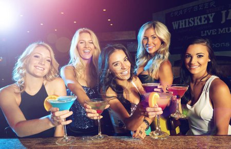 Foto de Amigos y divertidas vidas del tiempo bien. mujeres jóvenes tomando cócteles en un club nocturno - Imagen libre de derechos
