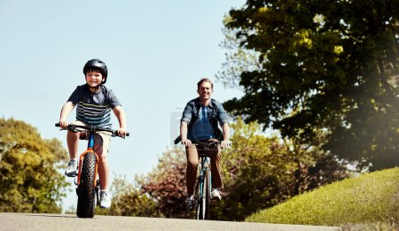 Foto de Veamos quién llega primero a la meta. un niño y su padre montando juntos en sus bicicletas - Imagen libre de derechos