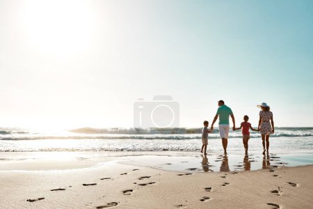 Promenade dans le paradis ensemble. une famille qui passe un bon moment ensemble à la plage