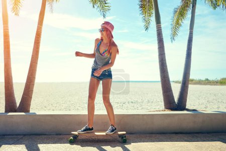 Photo for Im just cruising around. a young woman hanging out on the boardwalk with her skateboard - Royalty Free Image