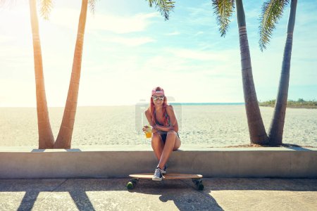 Photo for Squeeze out the fun in every day. a young woman hanging out on the boardwalk with her skateboard - Royalty Free Image