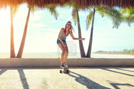 Photo for Girls who skate are the best. a young woman hanging out on the boardwalk with her skateboard - Royalty Free Image