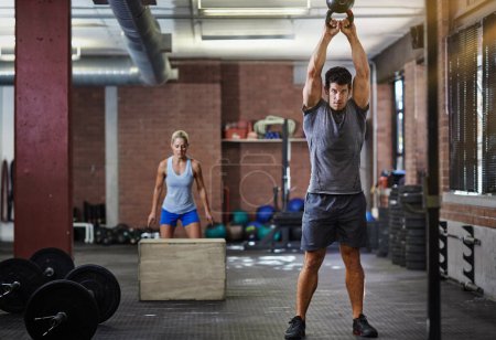 Photo for Theyre making this workout count. two people working out with kettlebells in a gym - Royalty Free Image