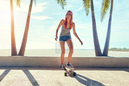 Photo for Im just one of the boys. a young woman hanging out on the boardwalk with her skateboard - Royalty Free Image