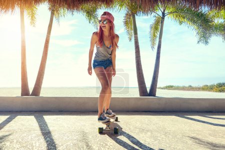 Photo for Put the fun under your feet. a young woman hanging out on the boardwalk with her skateboard - Royalty Free Image