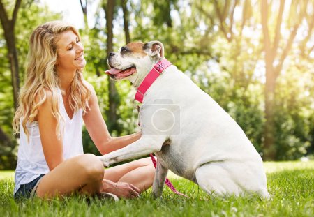 Le meilleur thérapeute a quatre jambes et une queue. une jeune femme passe du temps avec son chien au parc
