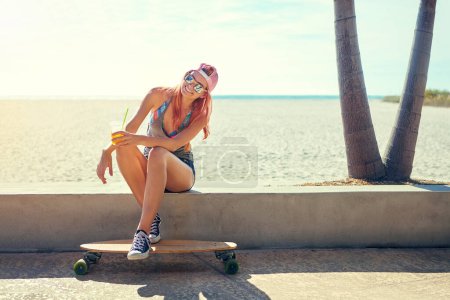 Photo for I find happiness from a piece of wood. a young woman hanging out on the boardwalk with her skateboard - Royalty Free Image