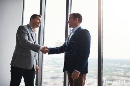 Photo for Joining forces. Low angle shot of two corporate businessmen shaking hands during a meeting in the boardroom - Royalty Free Image