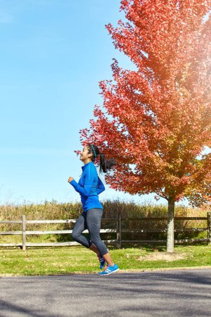 Foto de Al final, voy a alcanzar mis metas. una joven deportista corriendo al aire libre - Imagen libre de derechos