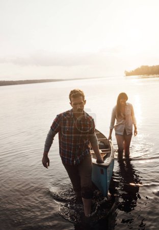 Foto de Gran día, pero ahora debemos seguir nuestro camino. una joven pareja que viene de un paseo en canoa en el lago - Imagen libre de derechos