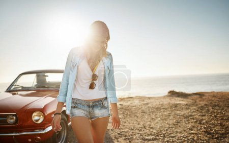 Téléchargez les photos : Dehors et en plein air. une belle jeune femme faisant un road trip à la plage - en image libre de droit