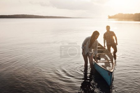 Photo for Ready to go. a young couple coming from a canoe ride on the lake - Royalty Free Image