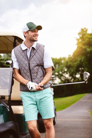 Téléchargez les photos : Le début d'une journée de golf. un beau jeune homme appuyé contre une voiturette de golf sur un terrain de golf - en image libre de droit