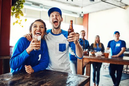 Photo for Sports binds you together. a young couple having beer while watching the game in a bar - Royalty Free Image