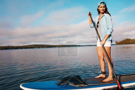 Téléchargez les photos : Je m'amuse bien sur l'eau. une jeune femme pagaie sur un lac - en image libre de droit