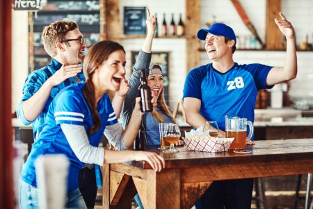 Foto de Diversión deportiva con amigos. un grupo de amigos animando mientras ve un partido de deportes en un bar - Imagen libre de derechos