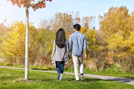 Foto de Aférrate a las cosas que importan en la vida. una pareja joven y cariñosa para dar un paseo por el parque - Imagen libre de derechos